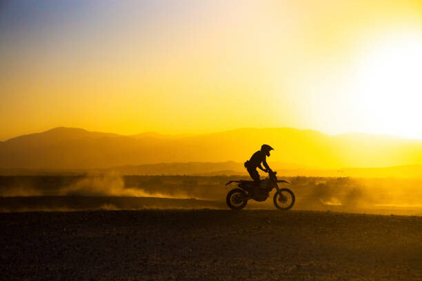 Matthew Micah Wright Umělecká fotografie A motorcycle races through the desert., Matthew Micah Wright, (40 x 26.7 cm)