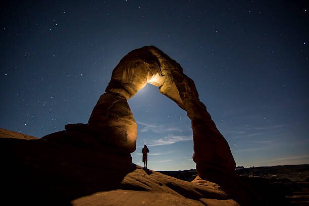 Jordan Siemens Umělecká fotografie A hiker standing underneath an arch., Jordan Siemens, (40 x 26.7 cm)