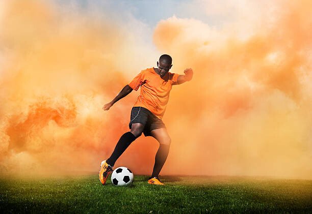 Henrik Sorensen Umělecká fotografie football player in orange smoke, Henrik Sorensen, (40 x 26.7 cm)