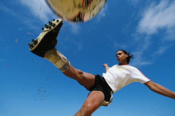 David Madison Umělecká fotografie Soccer player kicking ball, low angle, David Madison, (40 x 26.7 cm)