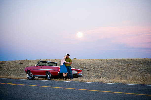 Mike Kemp Umělecká fotografie man and woman next to a red convertible, Mike Kemp, (40 x 26.7 cm)