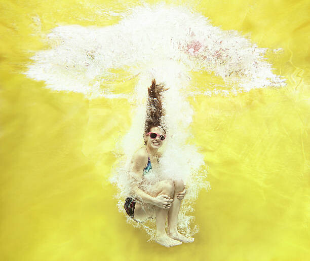 Stanislaw Pytel Umělecká fotografie Girl jumping into water on yellow background, Stanislaw Pytel, (40 x 35 cm)