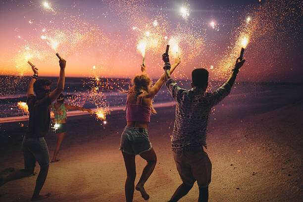 wundervisuals Umělecká fotografie Friends running on a beach with fireworks, wundervisuals, (40 x 26.7 cm)