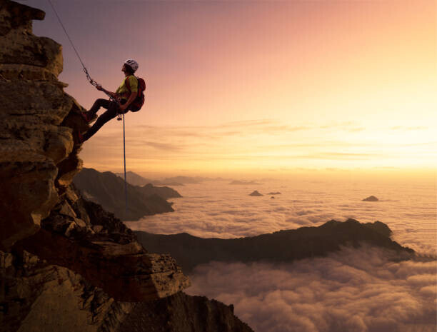 Buena Vista Images Plakát, Obraz - Climber on a rocky wall over clouds, Buena Vista Images, 40 × 30 cm