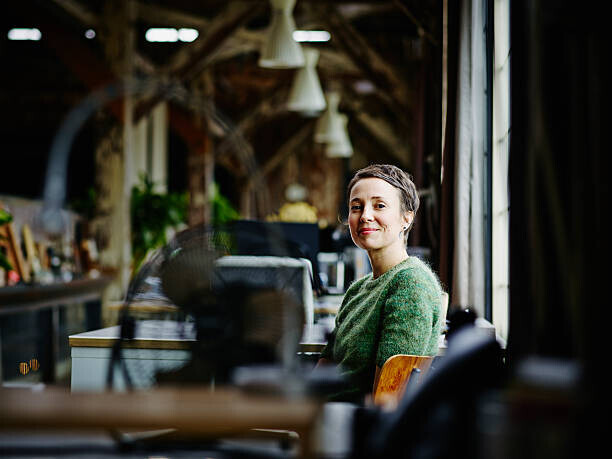 Thomas Barwick Plakát, Obraz - Smiling businesswoman sitting at workstation, Thomas Barwick, 40 × 30 cm
