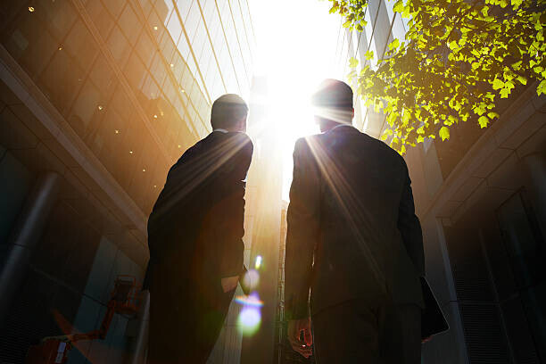 Ezra Bailey Plakát, Obraz - Two businessmen looking up into the sun., Ezra Bailey, 40 × 26.7 cm
