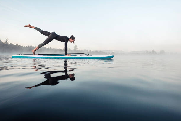 Westend61 Plakát, Obraz - Woman practicing paddle board yoga on, Westend61, 40 × 26.7 cm