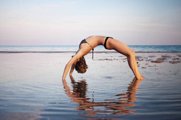 Cavan Images Plakát, Obraz - Woman wearing bikini doing yoga at, Cavan Images, 40 × 26.7 cm