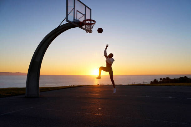 Heshphoto Plakát, Obraz - Mid adult woman playing basketball at sunset, Heshphoto, 40 × 26.7 cm
