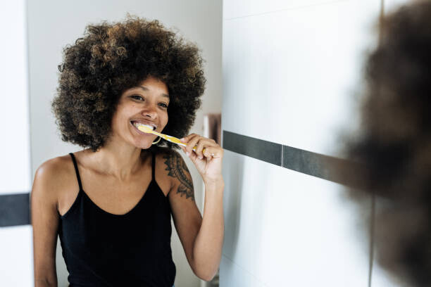 Drazen_ Plakát, Obraz - Multiracial woman brushing teeth in bathroom, Drazen_, 40 × 26.7 cm