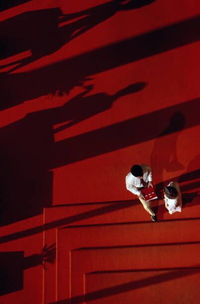 Will & Deni McIntyre Plakát, Obraz - Executives conferring in lobby, shadows and stairs, Will & Deni McIntyre, 26.7 × 40 cm
