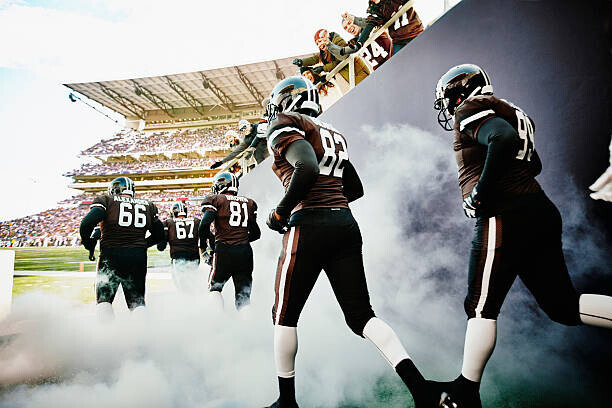 Thomas Barwick Plakát, Obraz - Fans cheering football team running out of tunnel, Thomas Barwick, 40 × 26.7 cm