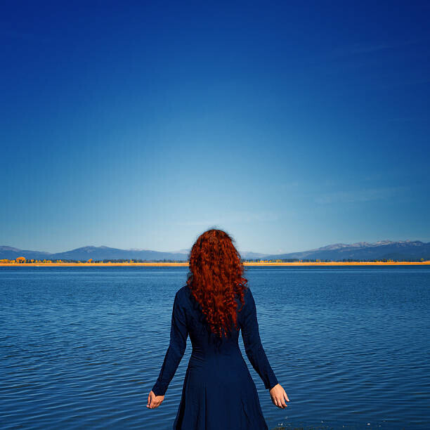 Anna Gorin Plakát, Obraz - Redhead in blue dress faces rippled lake, Anna Gorin, 40 × 40 cm