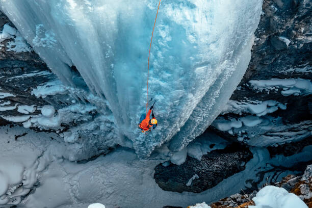 Alex Ratson Plakát, Obraz - A woman ice climbs up a, Alex Ratson, 40 × 26.7 cm