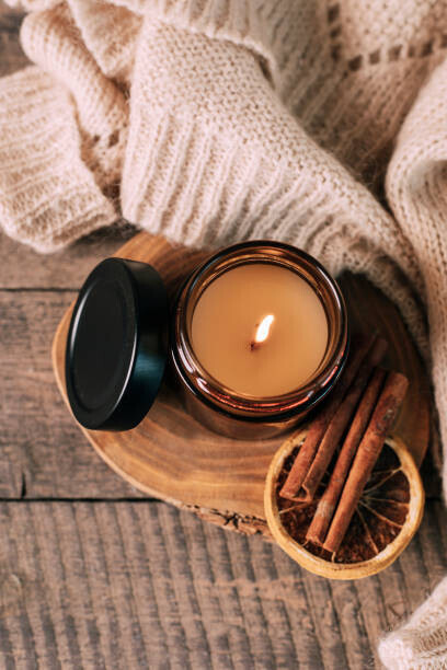 Alexandr Kolesnikov Plakát, Obraz - Candle in small amber glass jar with wooden wick on wooden stand on background. Top view, Alexandr Kolesnikov, 26.7 × 40 cm