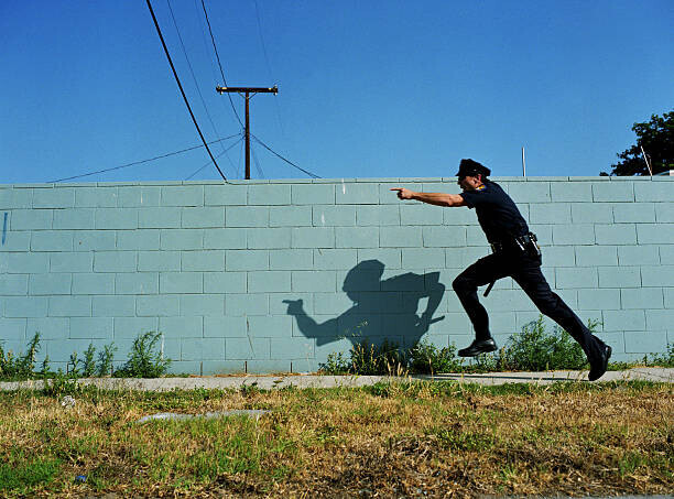 Sean Murphy Plakát, Obraz - Policeman running next to cement wall,, Sean Murphy, 40 × 30 cm
