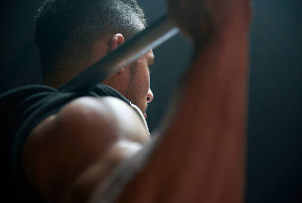 Tara Moore Plakát, Obraz - Male athlete lifting weight bar black background, Tara Moore, 40 × 26.7 cm